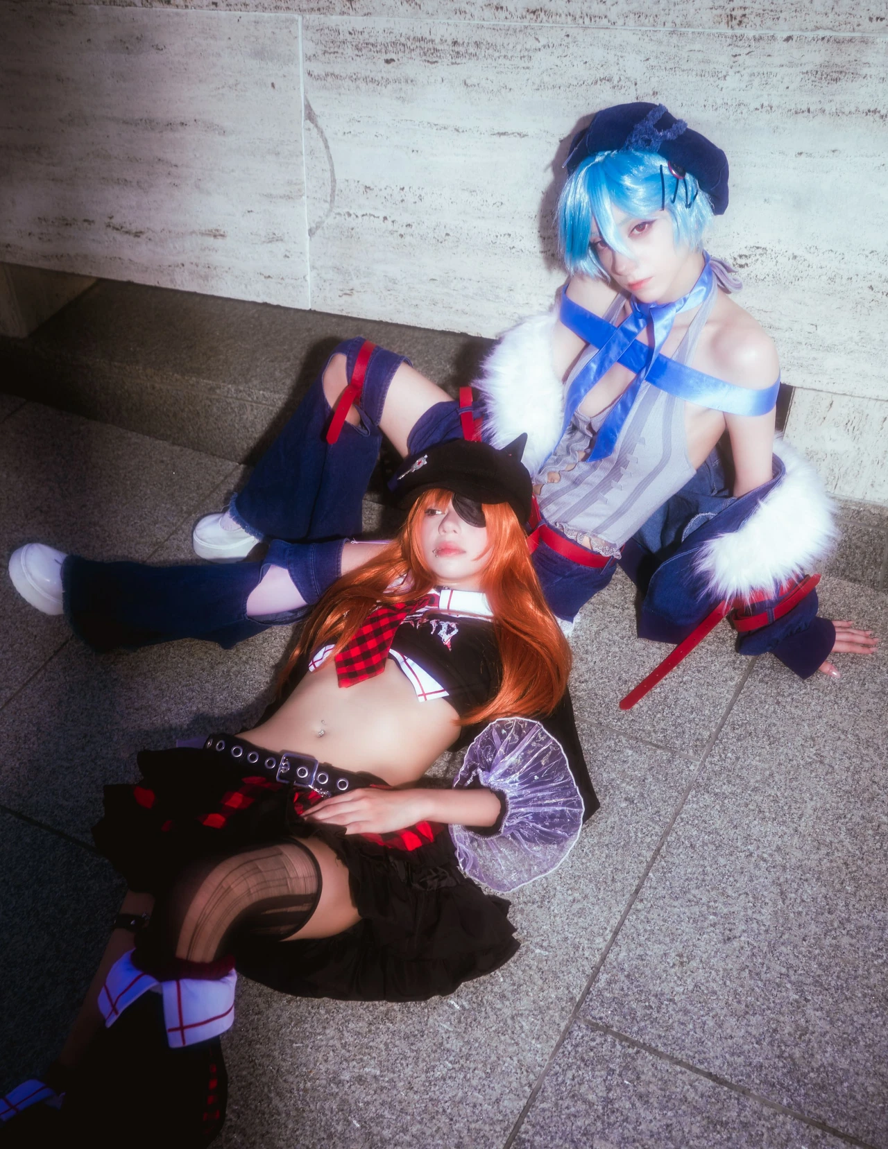 Rei cosplay leaning above Asuka reclining on stone steps.