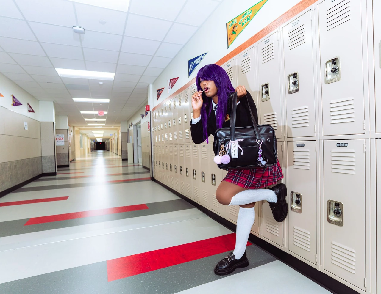 Purple-haired cosplayer in a school uniform lifting one foot beside the lockers.